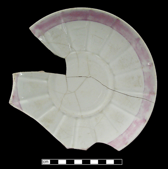 White earthenware jug dipped in blue slip, with painted purple luster floral decoration on both the slipped upper area (fugitive) and the central portion of the jug where the slip has been removed.  Purple luster also painted along beaded rim and spout.